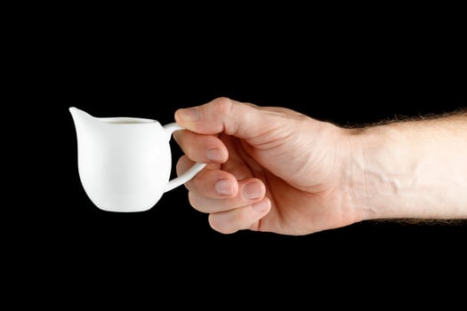 A white man's hand holds a Creamer isolate photo