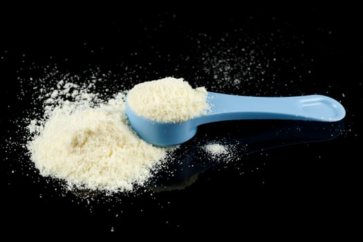Baby food and a blue spoon. Yellow powder for baby food. photo