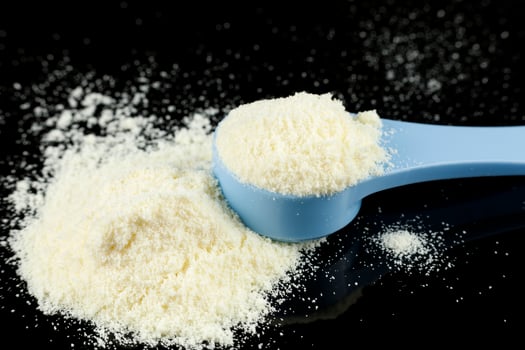 Baby food and a blue spoon. Yellow powder for baby food. photo