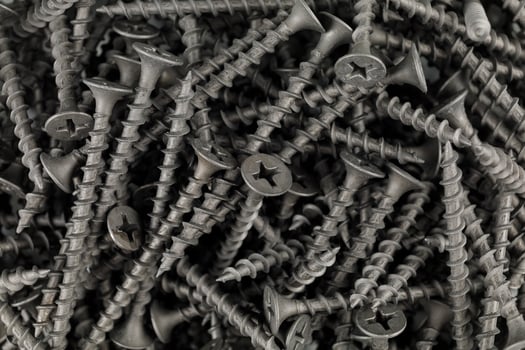 screws for wood close-up. many black screws. Background from steel screws photo