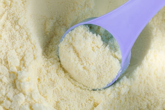 Baby food and a blue spoon. Yellow powder for baby food. photo