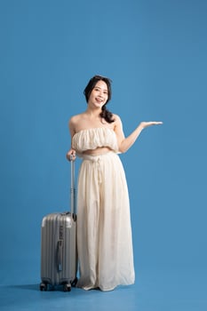 Portrait of asian girl posing on blue background, traveling in summer photo