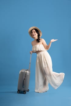 Portrait of asian girl posing on blue background, traveling in summer photo