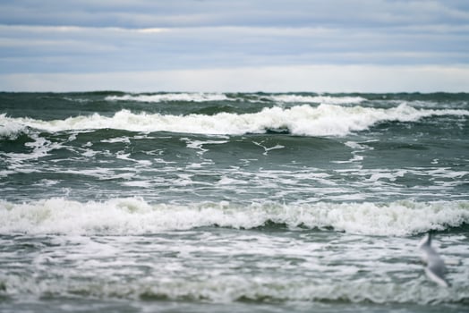 Blue sea with foaming waves and cloudy sky, seascape photo