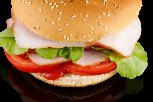 Burger with meat, lettuce, cheese and tomatoes close up photo