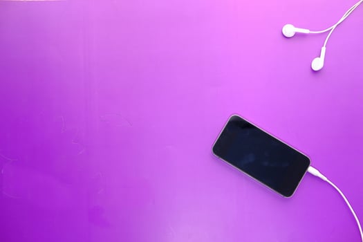 smart phone and earphone on purple background . photo