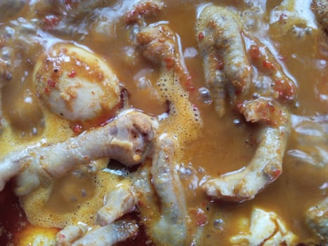 Chicken feet and spicy egg rendang sauce or spicy chicken feet rendang. typical food from Indonesia photo