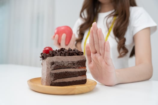 Beauty slim female body confuse chocolate cake. Woman in restaurant achieves weight loss goal for healthy life, crazy about thinness, thin waist, nutritionist. Diet, body shape. photo