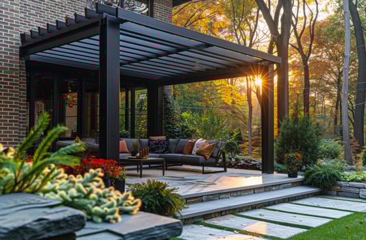 Modern metal pergola covers sitting area and stone patio in this backyard during sunset. photo