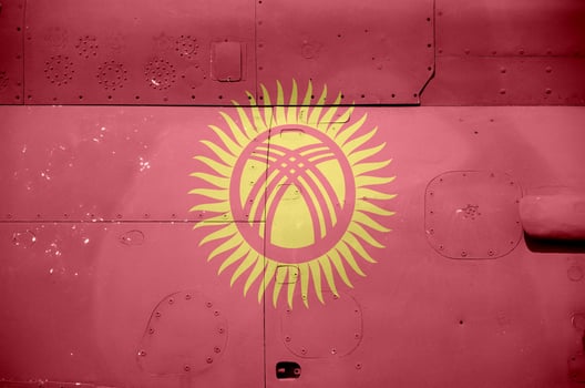 Kyrgyzstan flag depicted on side part of military armored helicopter closeup. Army forces aircraft conceptual background photo