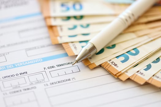 Filling italian tax form process with pen and euro money bills close up. Tax paying period photo