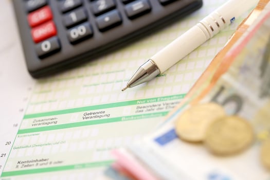 Filling german tax form process with pen and euro money bills close up. Tax paying period photo