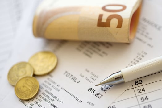 Heap of euro money bills in stationery clip on papers with calculations and receipts. Business and accounting concept photo