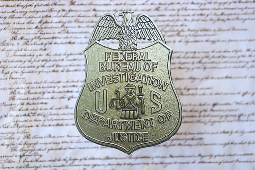 KYIV, UKRAINE - MARCH 9, 2024 US FBI Federal Bureau of Investigation badge on United States Constitution photo