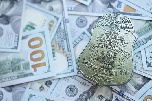 KYIV, UKRAINE - MARCH 9, 2024 US FBI Federal Bureau of Investigation badge on many US hundred dollar bills photo
