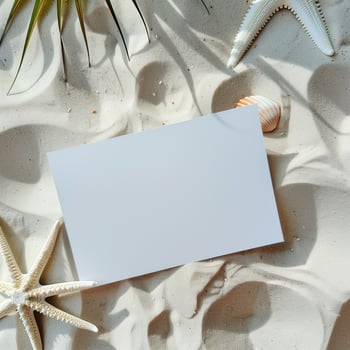 Blank paper on the sandy beach with seashells and starfish. photo