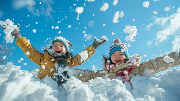 Children making snow angels in a field of fresh snow with a bright blue sky above photo