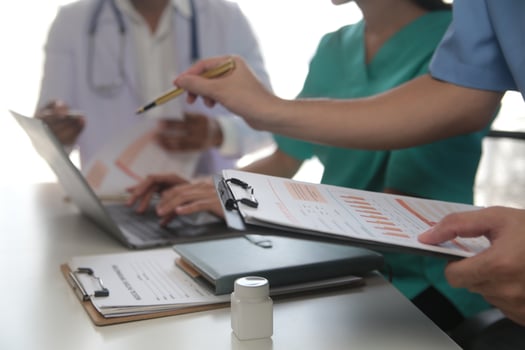 Medical Team Meeting Around Table In Modern Hospital photo