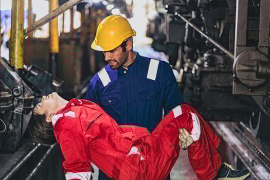 man in a yellow helmet is holding a woman in a red jumpsuit photo