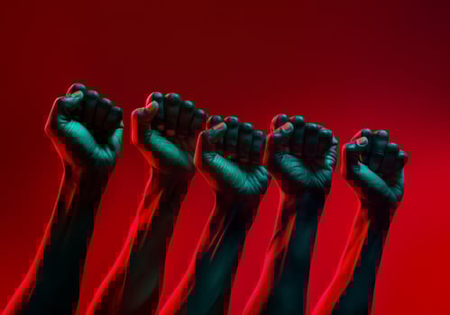 Black men's fists held up with green and red gradient colors. Black history, slavery , freedom background. photo