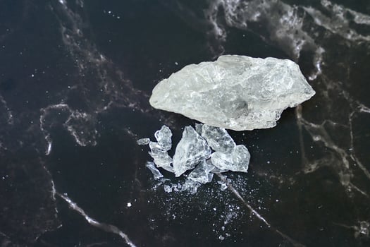 Lumps of alum on a black background. It is a mineral with clear, white crystals, odorless, astringent taste, ground into a white powder that resembles rock sugar. photo
