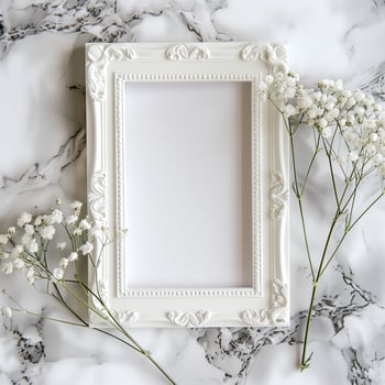 A white picture frame with an empty space inside, sitting on top of a marble surface. photo