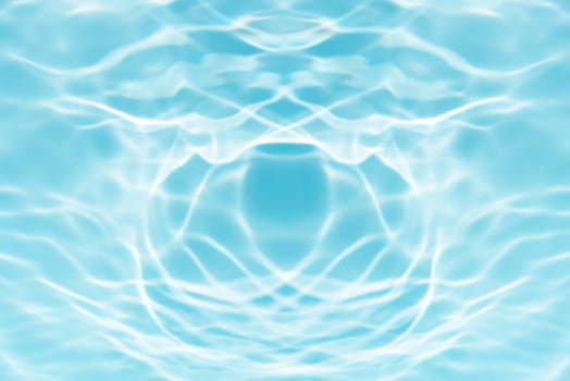 Blue water with ripples on the surface. Defocus blurred transparent blue colored clear calm water surface texture with splashes and bubbles. Water waves with shining pattern texture background. photo