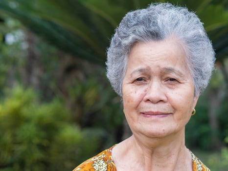 Senior woman with short gray hair, smiling and looking at the camera while standing outdoors. Space for text Concept of aged people and healthcare photo