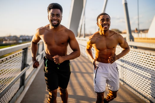 Two african-american friends are jogging on the bridge in the city. photo