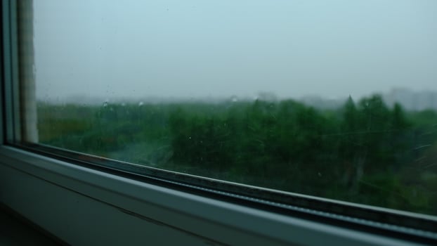 Raindrops on the window pane. Blurred background outside the window in the rain. photo