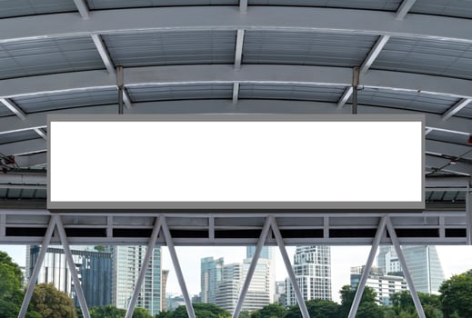 Mock up hanging white rectangle billboard at footbridge with cityscape background photo