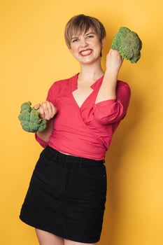 In the studio shot, a young Caucasian woman holds fresh broccoli in her hands. of the healthy eating concept. photo