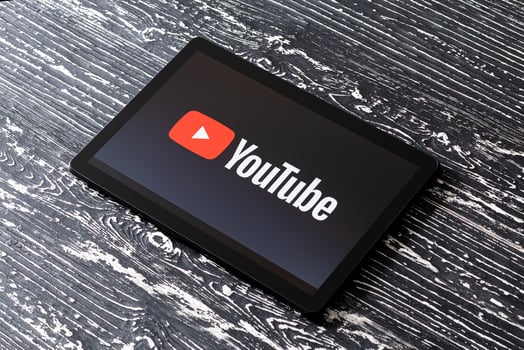 Tablet computer on a black wooden table with a social network YouTube logo on the screen. photo