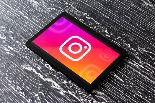 Tablet computer on a white wooden table with a social network instagram logo. photo