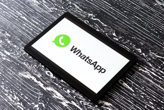 Tablet computer on a black wooden table with a messenger WhatsApp logo on the screen. photo
