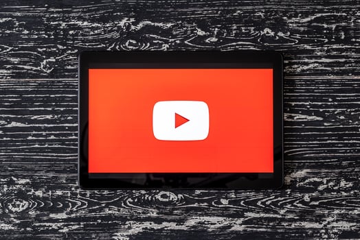 Tablet computer on a black wooden table with a social network YouTube logo on the screen. photo