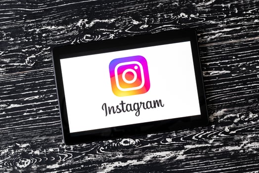 Tablet computer on a white wooden table with a social network instagram logo. photo