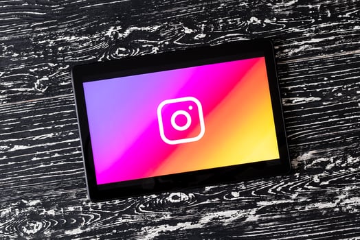 Tablet computer on a white wooden table with a social network instagram logo. photo