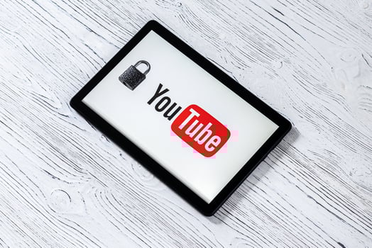 Black tablet computer on a white wooden table with a messenger youtube logo. photo