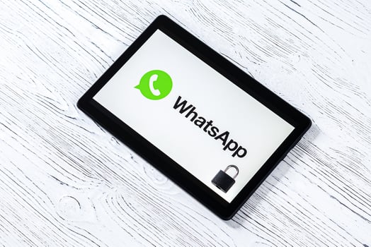 Black tablet computer on a white wooden table with a messenger whatsapp logo. photo