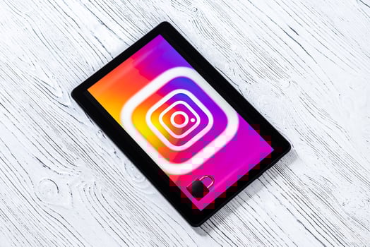 Black tablet computer on a white wooden table with a messenger instagram logo. photo