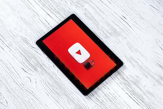 Black tablet computer on a white wooden table with a messenger youtube logo. photo