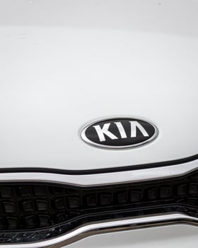 Russia, Kaluga - SEPTEMBER 29, 2020 Chromed Kia Motors logo on a white hood of a new car. photo