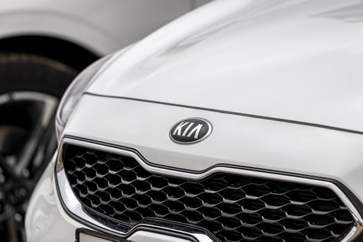 Russia, Kaluga - SEPTEMBER 29, 2020 Chromed Kia Motors logo on a white hood of a new car. photo