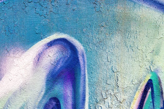 A fragment of colorful graffiti painted on a wall. Abstract urban background. photo