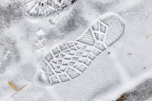 Boot track on thin first snow in winter. photo