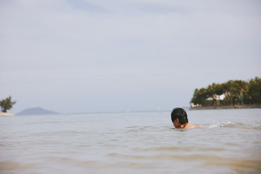 Smiling Asian Man Swimming in Tropical Blue Ocean. Vacation Bliss photo