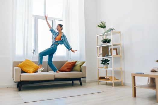 Joyful Woman Jumping with Music at Home. A Playful Concept of Carefree Lifestyle photo