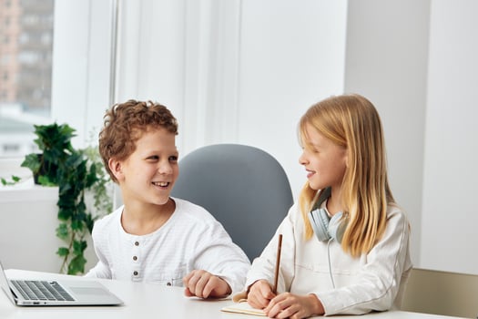 Happy Children Studying and Playing Online Brother and Sister with Laptops in the Living Room photo
