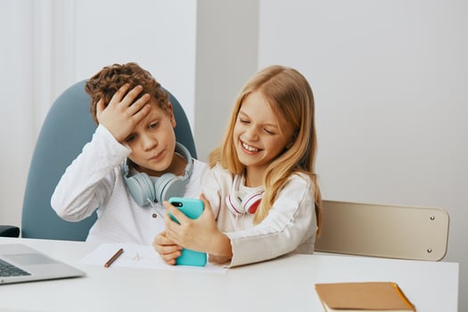 Happy Children Engaged in Online Learning Boy and Girl Studying with Laptops at Home photo